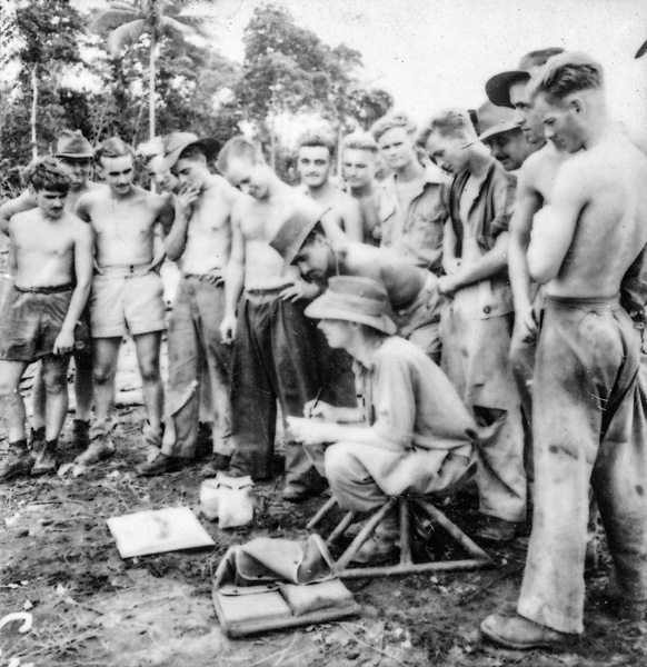 Ground crews on a Morotai airstrip gather around W.E. Pidgeon (W